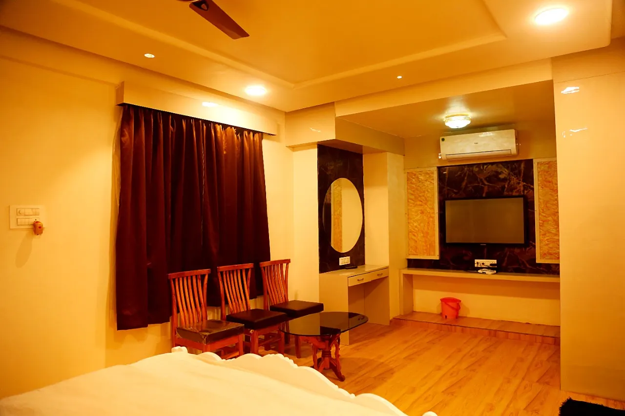 Warm-lit Evershine room with wooden chairs, mirror and TV wall